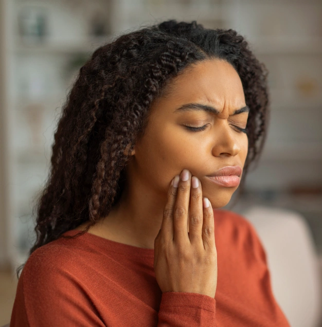 Patient holding jaw due to dental emergency pain